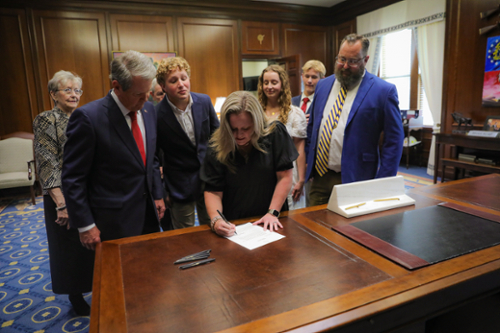 Middle Georgia State University’s Betsy McDaniel signing a document with Governor Brian Kemp. 